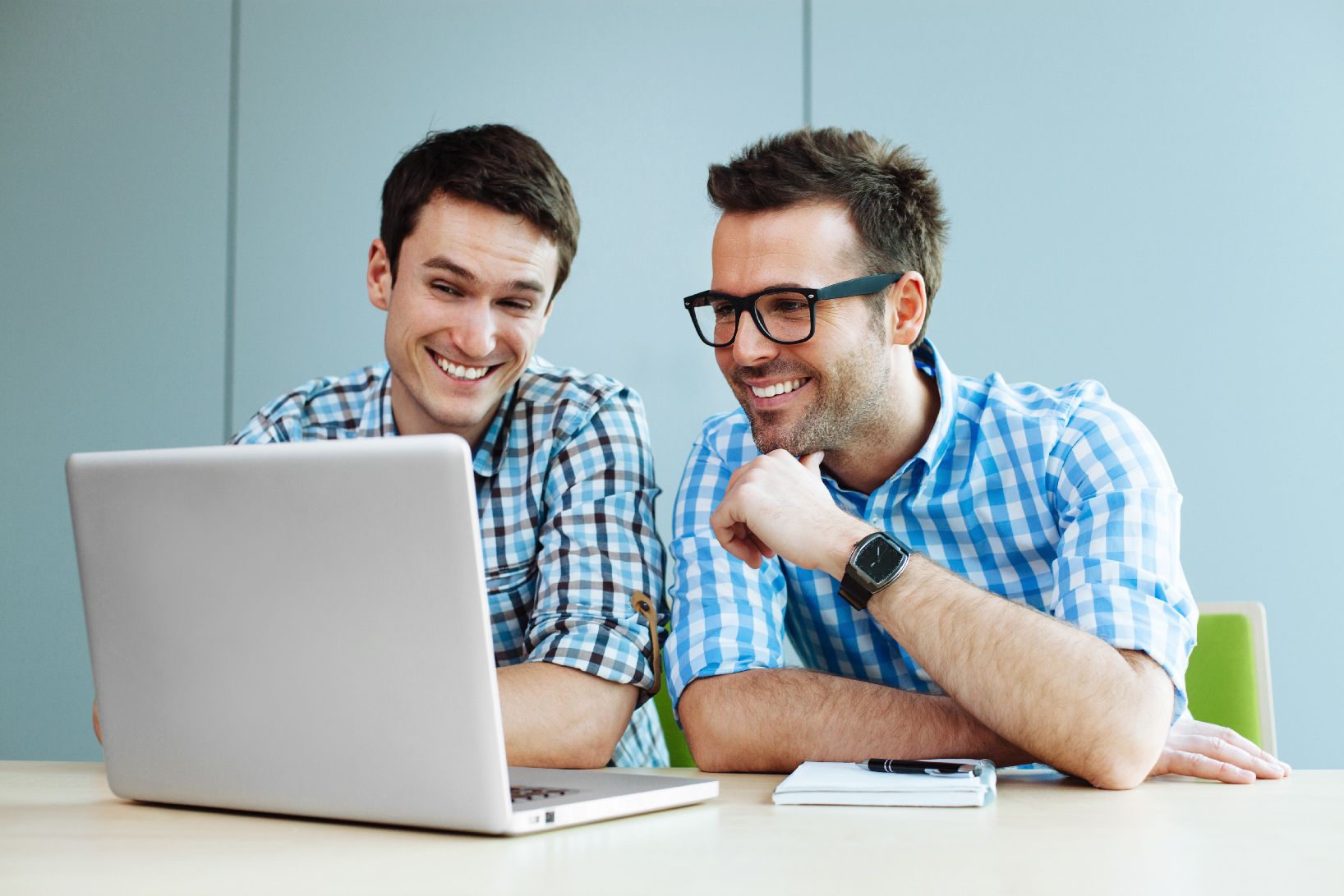 Two men looking at a computer